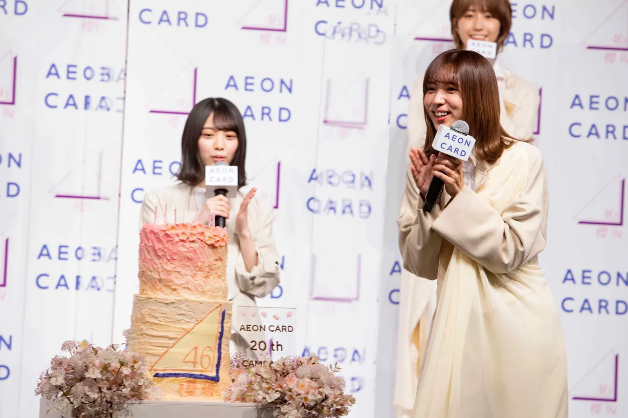 【写真を見る】イオンカード20周年と櫻坂46誕生を祝って、スペシャルケーキが登場！ 笑顔でのぞき込むメンバーたち