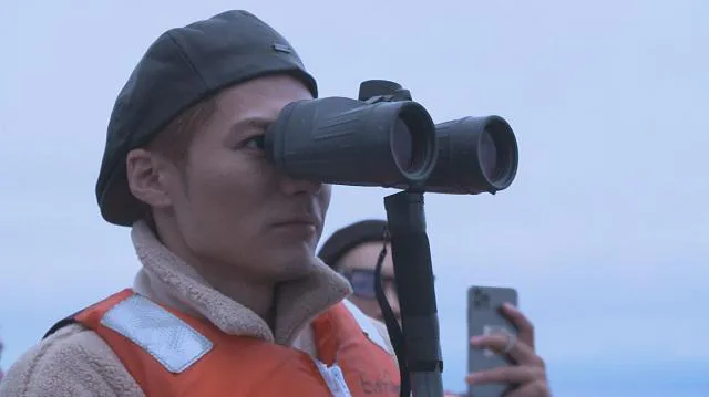 【写真を見る】双眼鏡を使ってシャチやクジラを探すEXILE SHOKICHI　©UHB/LDH