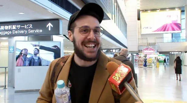 成田空港でインタビューに応じる男性外国人