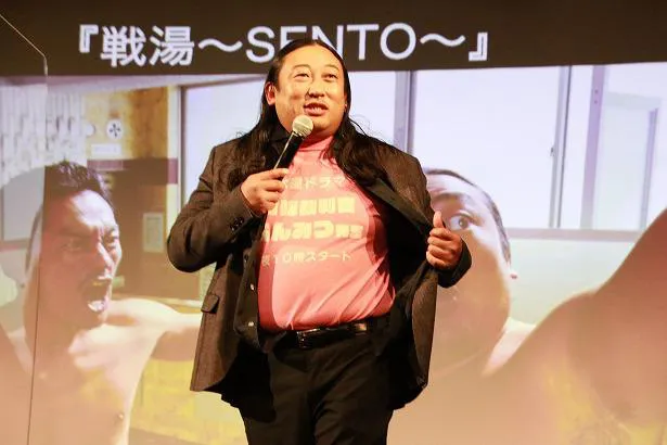 【写真を見る】ロバート秋山は架空のドラマの宣伝Tシャツを身に着けて登壇