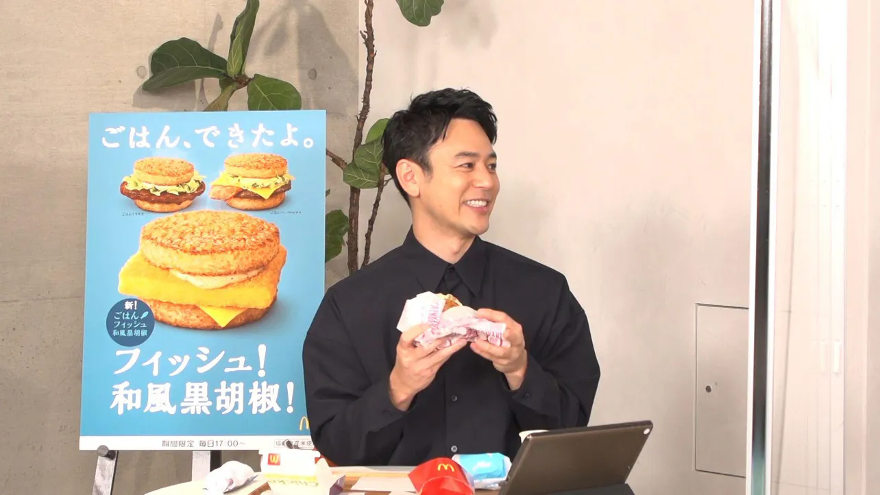 【写真を見る】「ごはんバーガー」を実食して満面の笑みがこぼれる妻夫木聡