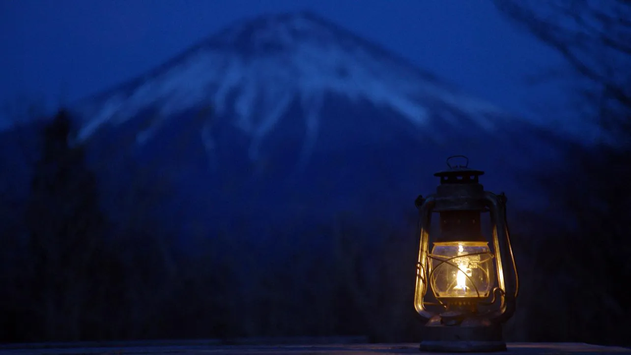 【写真を見る】富士山を背景に、ヒロシ愛用のオイルランタンがともる