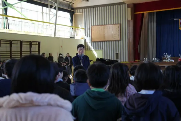 【写真を見る】中村が校歌を作った、市立鳴瀬桜華小学校へ。生徒たちは中村に校歌合唱を披露する