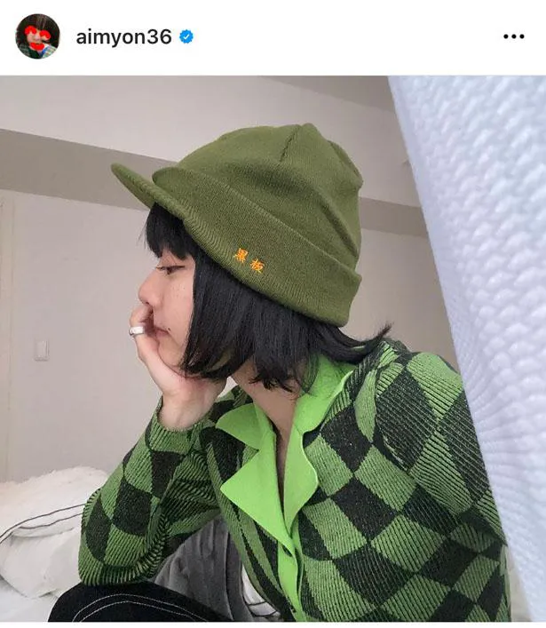 【写真を見る】モスグリーンの帽子に緑×黒のニットを着たあいみょん