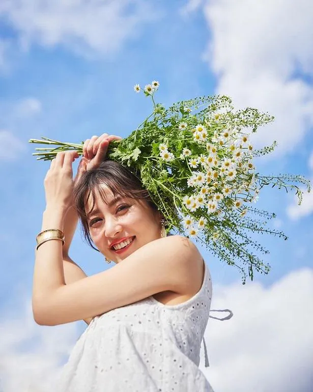 【写真を見る】石川恋は青空をバックに二の腕際立つ美しいノースリーブ姿で花束を持った笑顔写真を公開