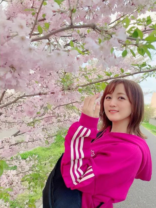 【写真を見る】カジュアルスタイルで桜を楽しむ小松彩夏