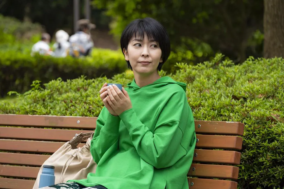 【写真を見る】鮮やかな緑の服を着てベンチに座ってゆっくりする大豆田とわ子(松たか子)
