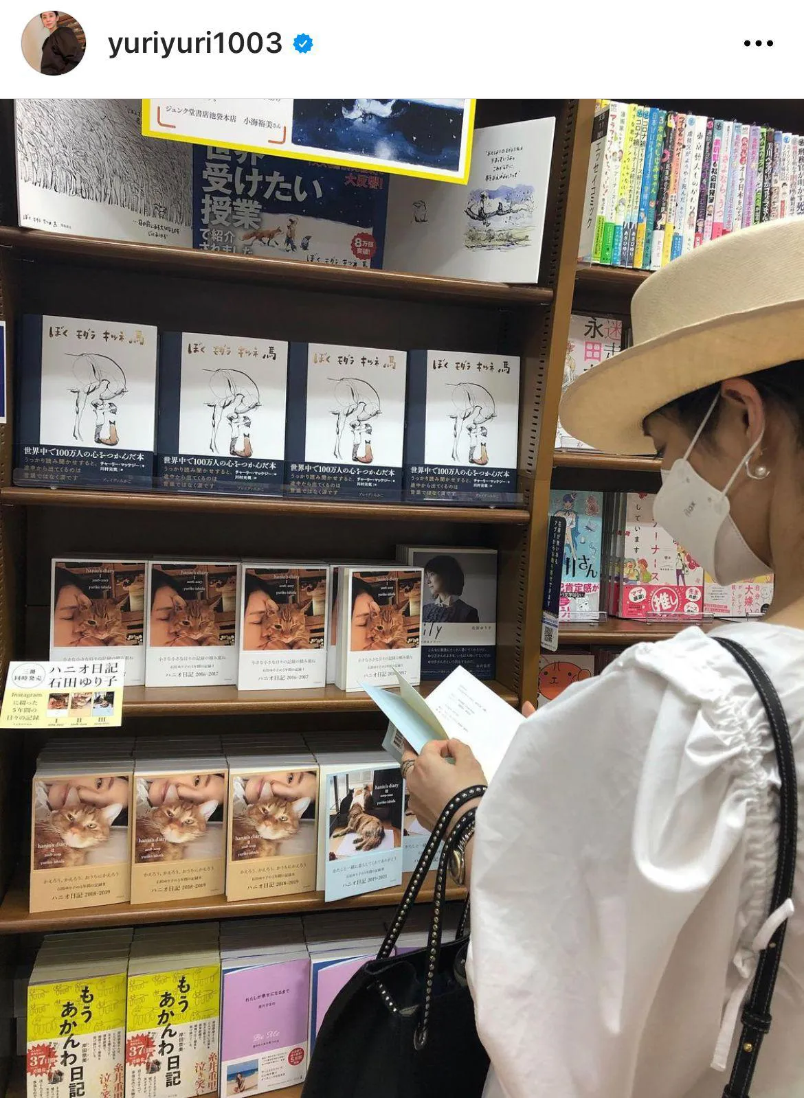 【写真を見る】おしゃれすぎる！自身の著書を本屋で立ち読みする石田ゆり子