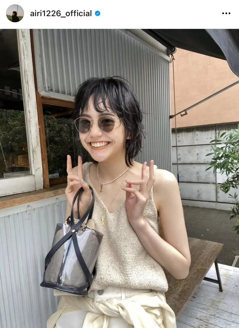 【写真を見る】タンクトップ姿で笑顔を見せるウルフカットの松井愛莉