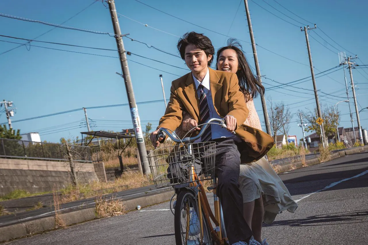 【写真を見る】楽しそう！一緒に自転車に乗って笑顔を見せる鈴鹿央士と秋田汐梨