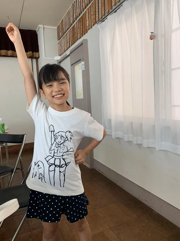 劇中アニメ「魔法左官少女バッファローKOTEKO」のTシャツを着てポーズを決める中島琴音