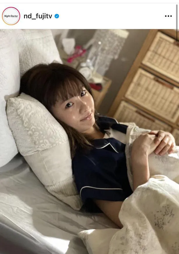 【写真を見る】ネイビーのパジャマを着て、ベッドに横たわる岡崎紗絵
