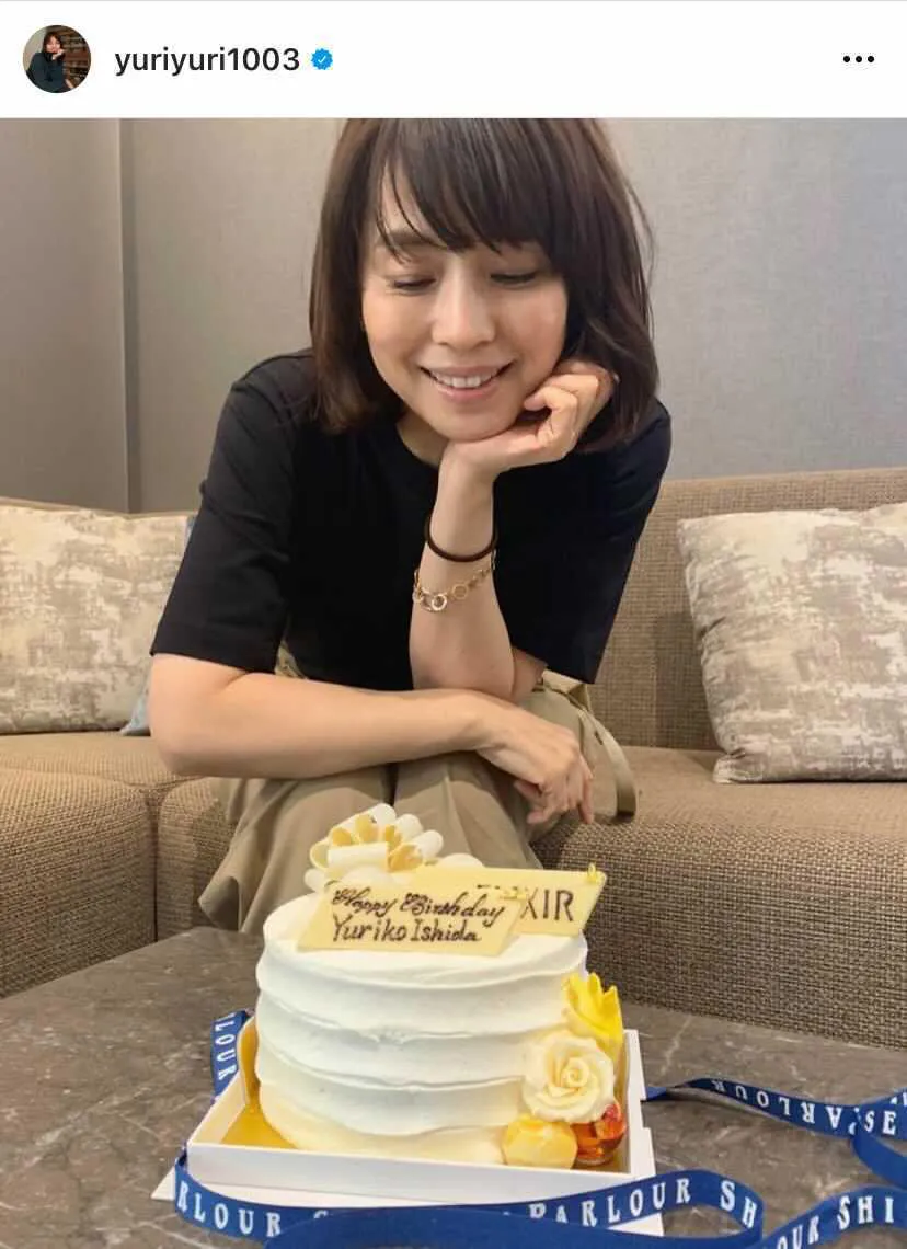 【写真を見る】ケーキを見つめながらほほ笑む石田ゆり子