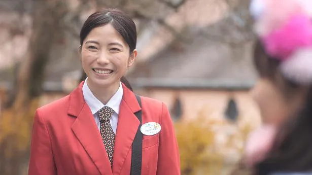 【写真を見る】横山由依、満面の笑みがかわいい！赤色の制服を着てパークコンシェルジュを演じる