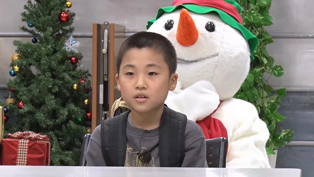 【写真を見る】雪だるまのぬいぐるみをバックに座るSnow Manファンの少年・登己臣くん