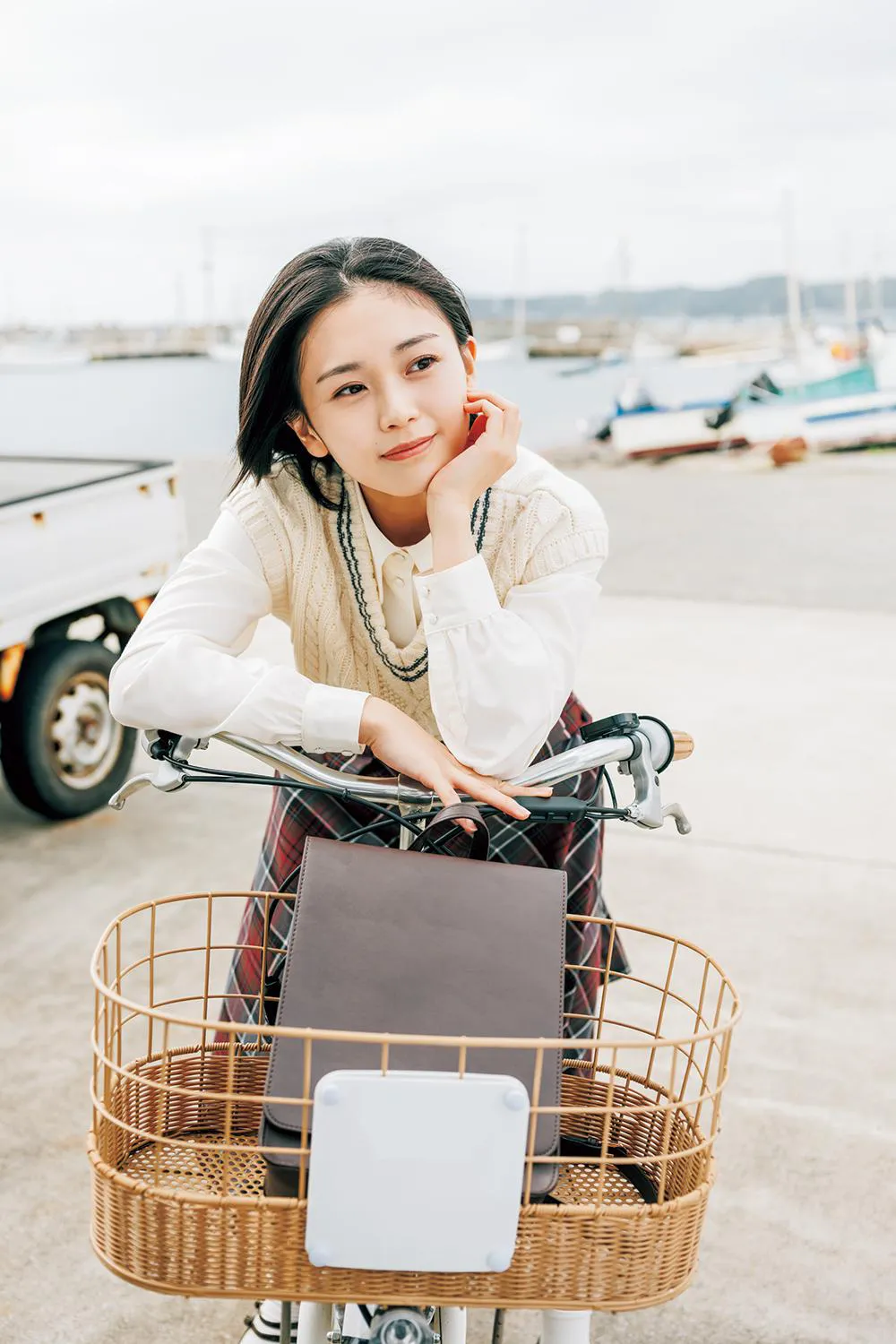 【写真を見る】千葉・勝浦の港をバックに自転車に乗る平井
