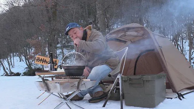【写真を見る】 雪上にテントを張りキャンプ飯を作る西村