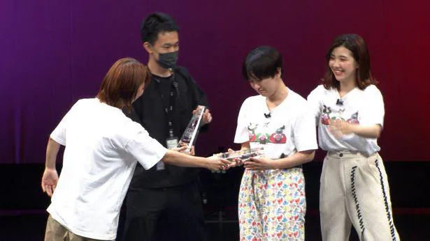 喜びの涙をこらえながらトロフィーを受け取る(写真左より)加納、サーヤ、福田麻貴