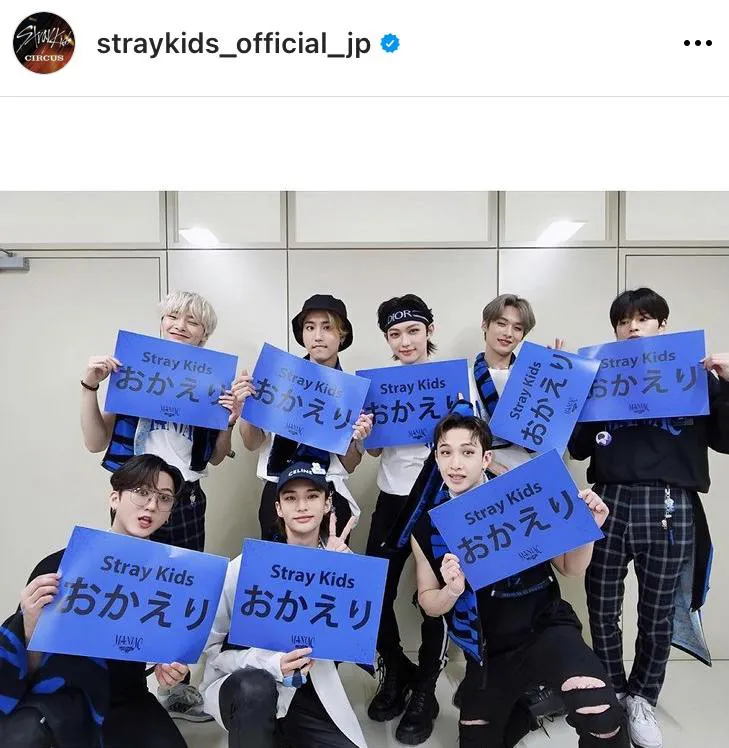 「Stray Kids おかえり」と書かれたプラカードを持つ笑顔のStray Kids