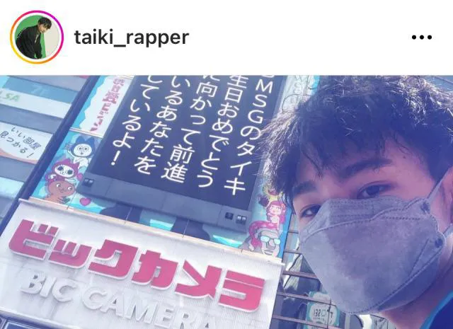 渋谷愛ビジョンへのお祝いメッセージをバックにしたTAIKI