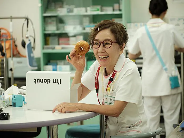 【写真】差し入れのドーナツを手にうれしそうな21歳の新人看護師・浅田美代子“西垣”