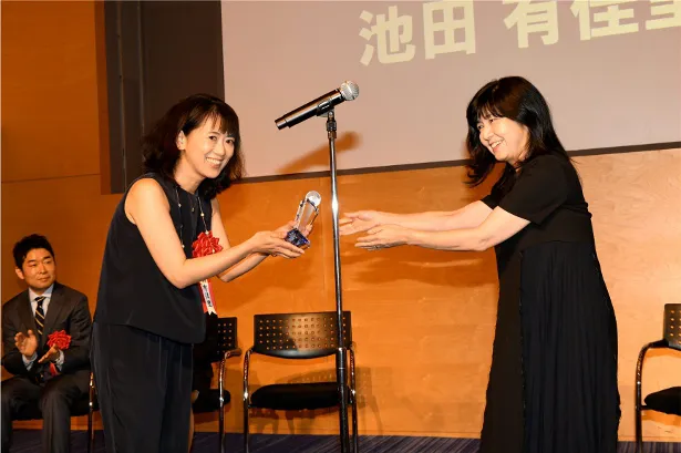 【写真を見る】井上由美子氏が大賞を受賞した池田有佳里氏にトロフィーを授与