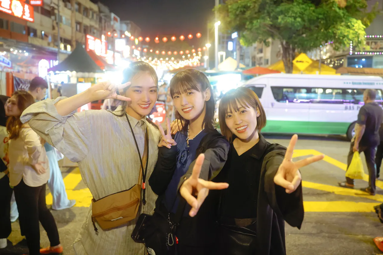 クアラルンプールの街中で楽しそうな笑顔を見せる山崎天、井上梨名、松田里奈(写真左から)