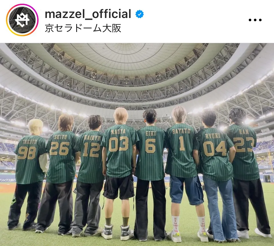 【写真】グランドにユニフォーム姿で一列に並ぶMAZZEL8人の後ろ姿がかっこいい