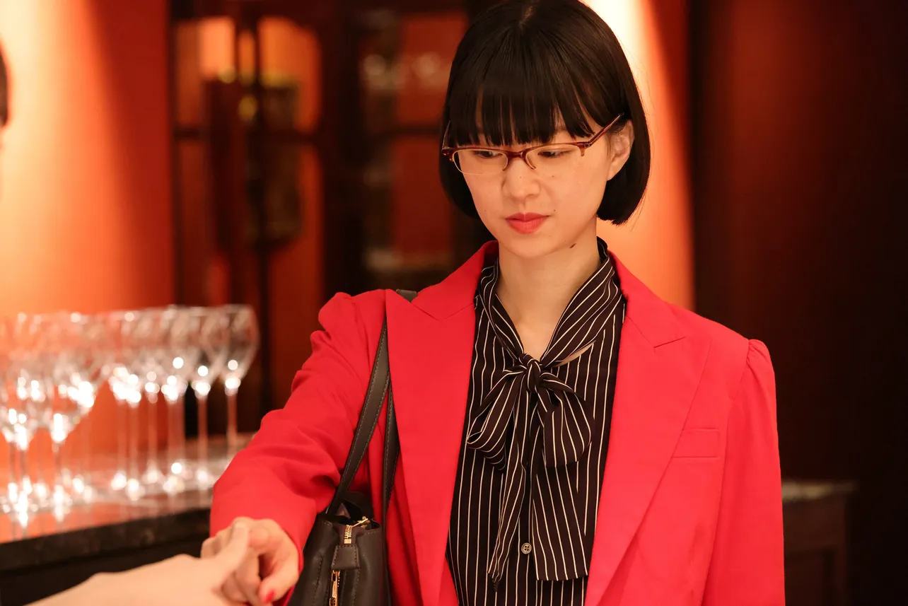 【写真】赤いジャケット姿が美しい橋爪リリ子を演じる片山友希