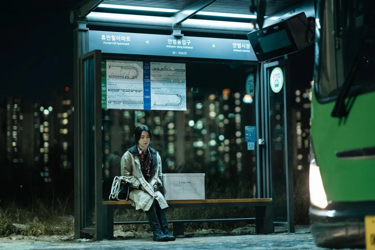 【写真】バス停のベンチでうつろな表情のイム・ジヨン“サンウン”