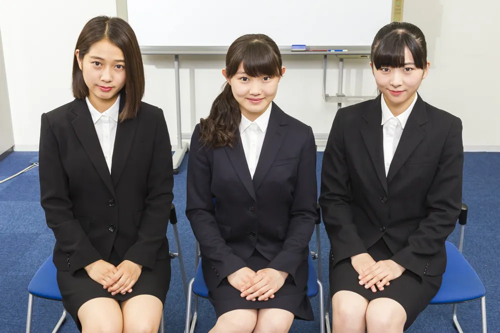 サブリーダーの小片リサ、谷本安美、小野田紗栞の3人が、新曲のひとつ「就活センセーション」の衣装であるリクルートスーツを着て登場！