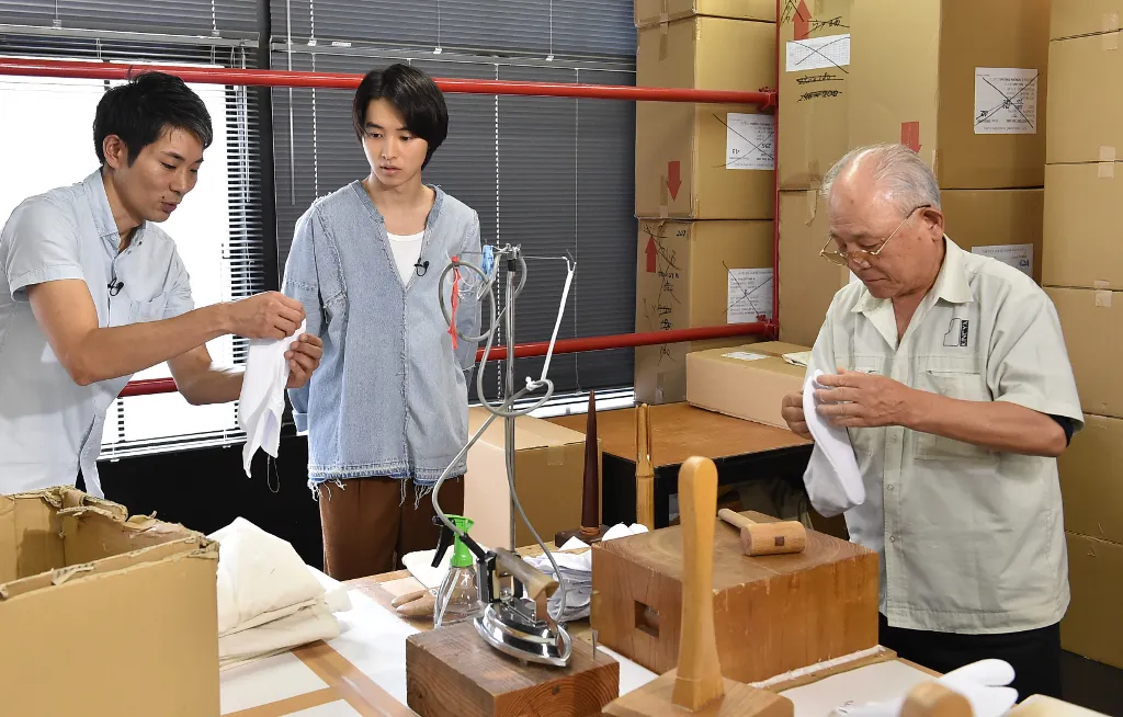 【写真を見る】足袋作りの工程を見学する山崎