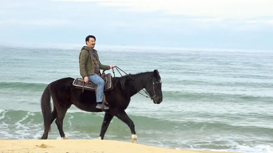 【写真を見る】「小田井涼平のあい旅」で、小田井は福岡・志賀島の浜で乗馬体験