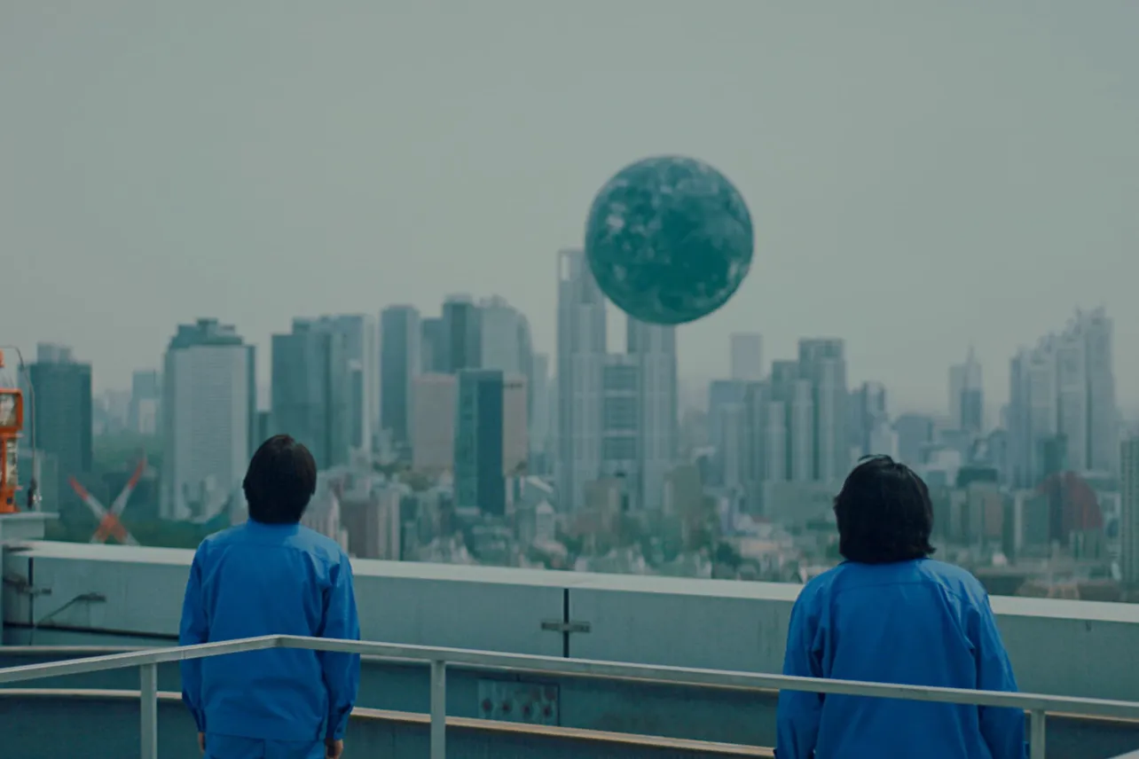 【写真】宙に浮く謎の球体を見あげる2人のうしろ姿