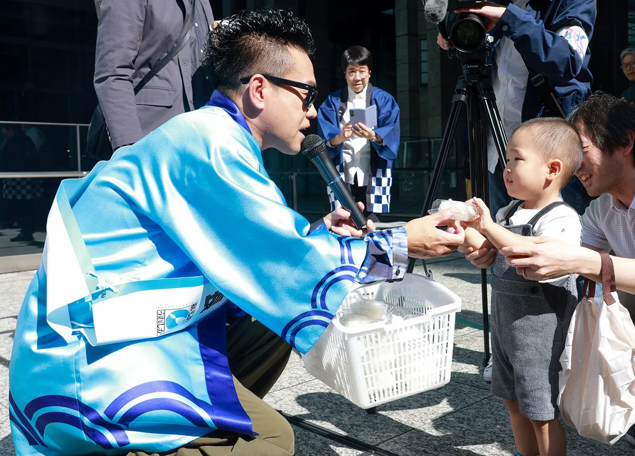 【写真】優しい笑顔とフレンドリーな声掛けで集まった人々におにぎりを配る宮川大輔