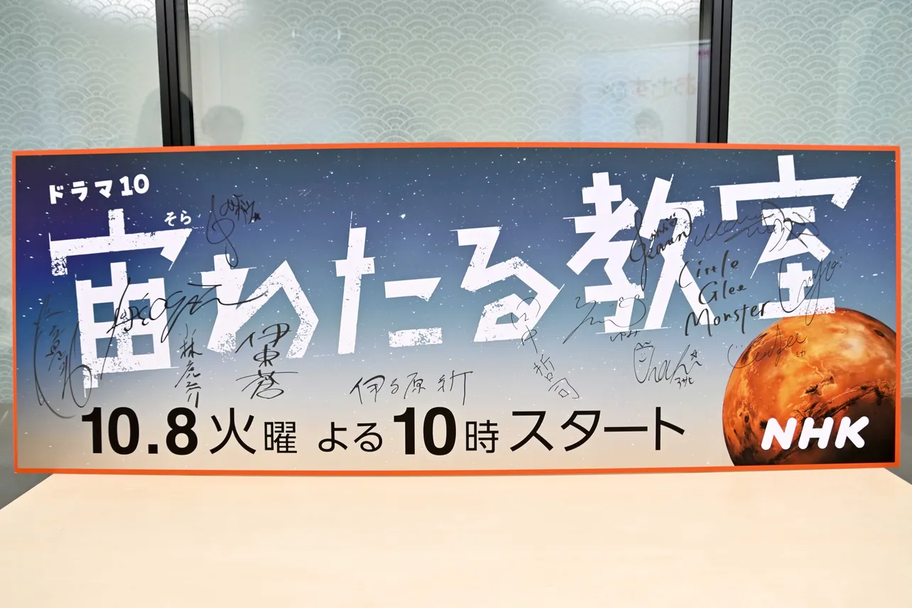 実際に会見で使われた巨大パネル　出演者たちのサインも寄せられている