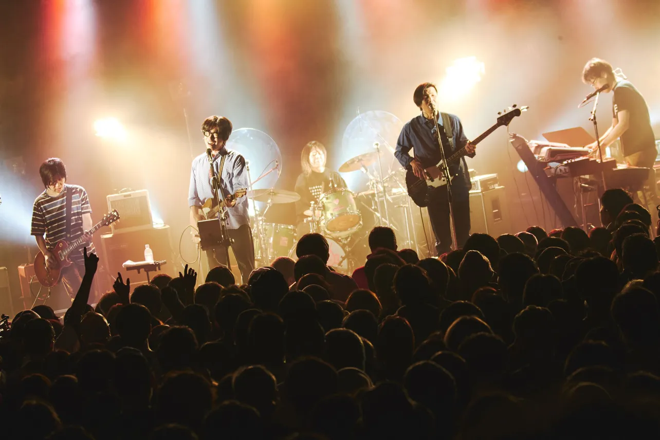 【写真】観客が熱狂する中、光に照らされ演奏するくるりのライブショット