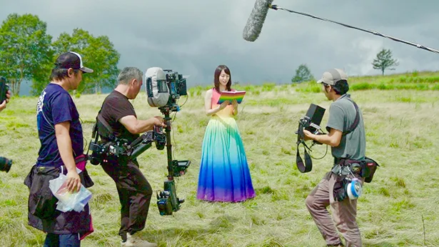 【写真を見る】大草原にレインボーカラーのドレスが映える