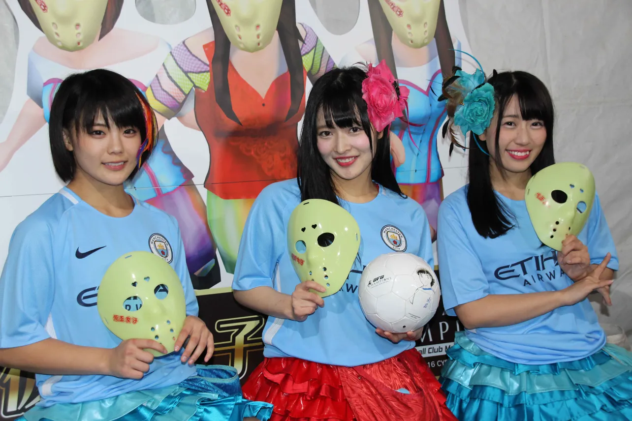 自分たちをモデルにしたボードの前に並ぶ川村虹花、北村真姫、楠木まゆ(写真左から)