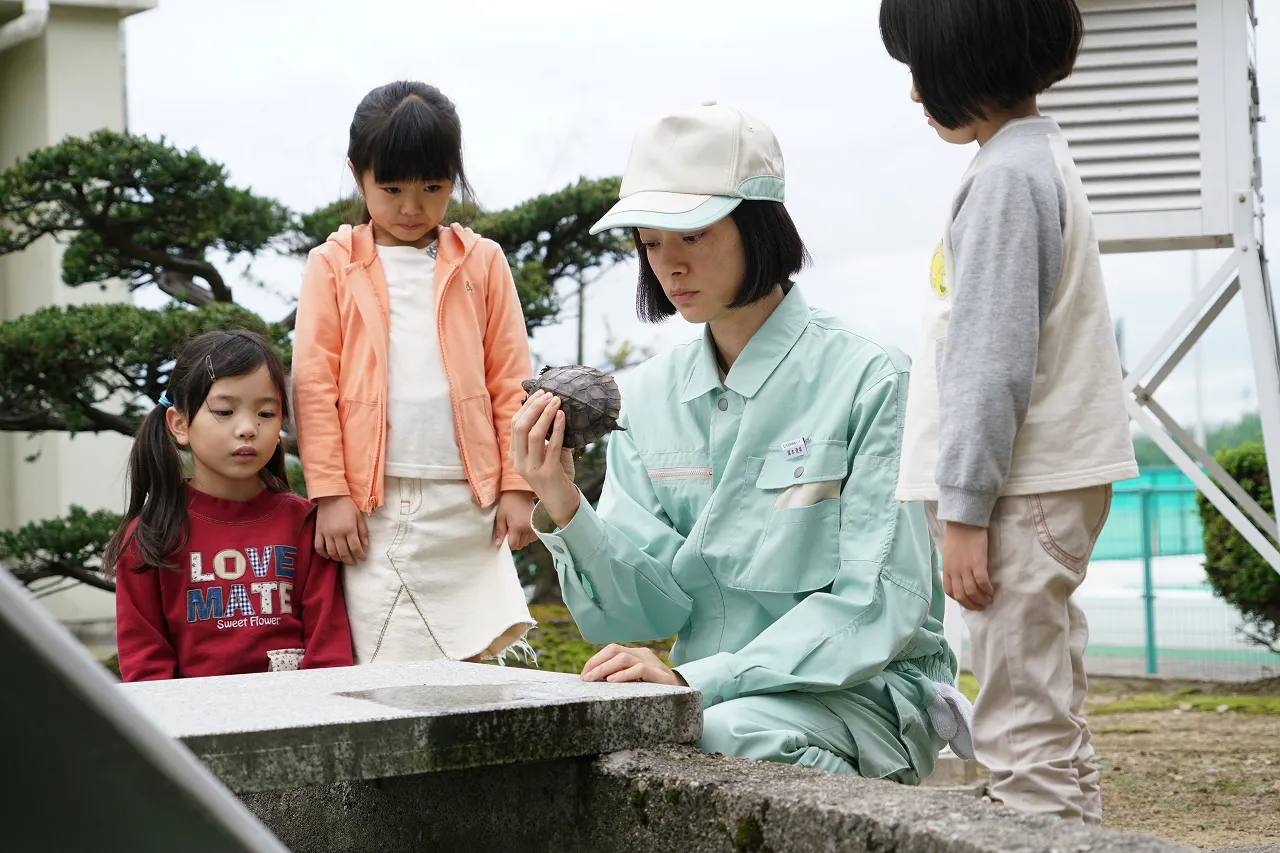 子供たちに囲まれる清掃員の栗本(市川実日子)