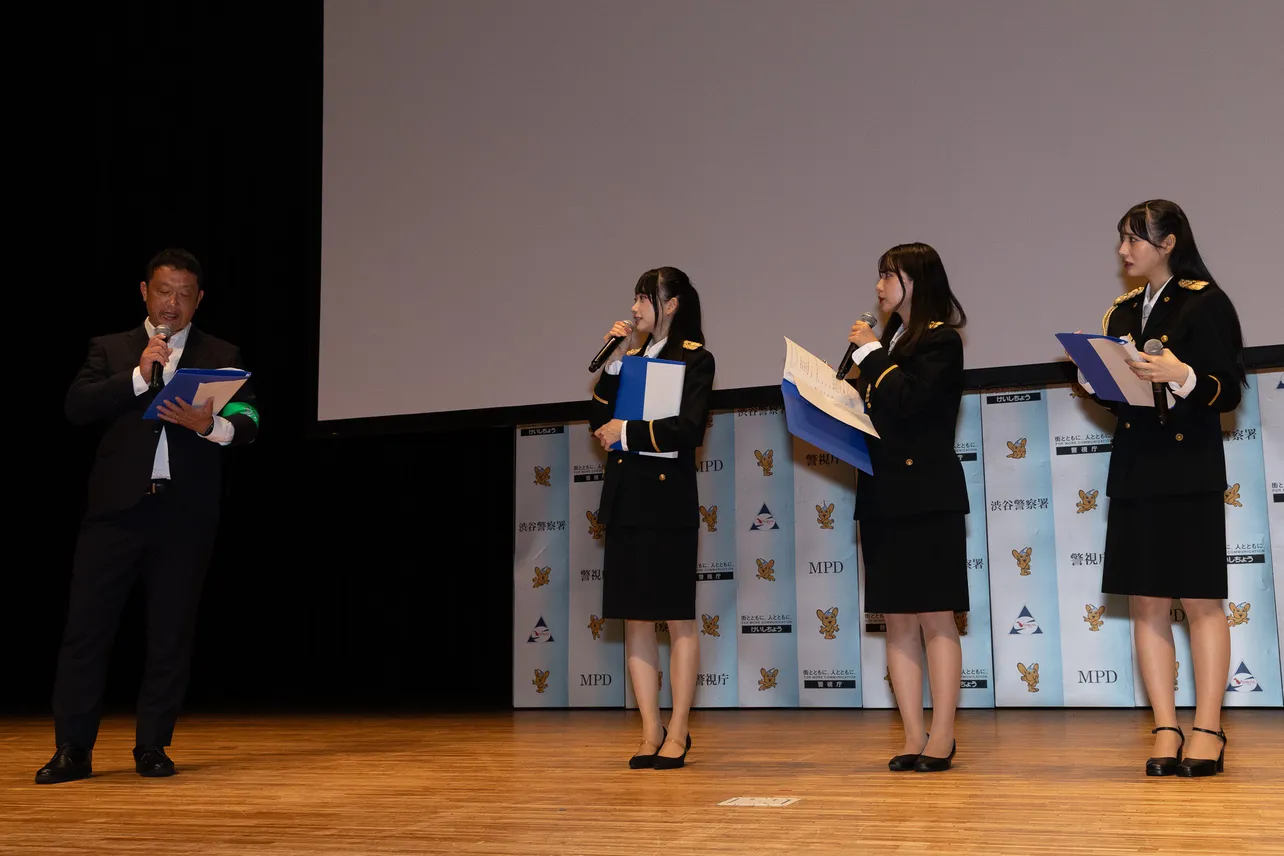 渋警察署の特殊詐欺担当からアドバイスを受けるRain Treeの橋本真希、仲俣美希、佐藤莉華(左から)