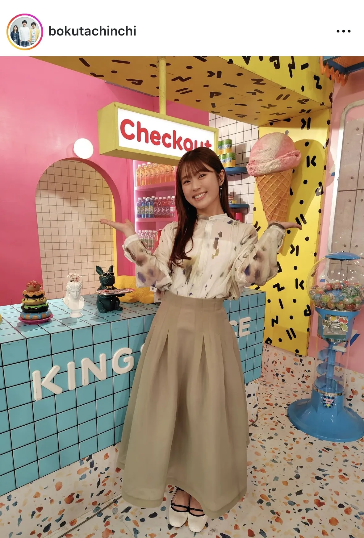 カラフルな空間で両手を広げる渋谷凪咲