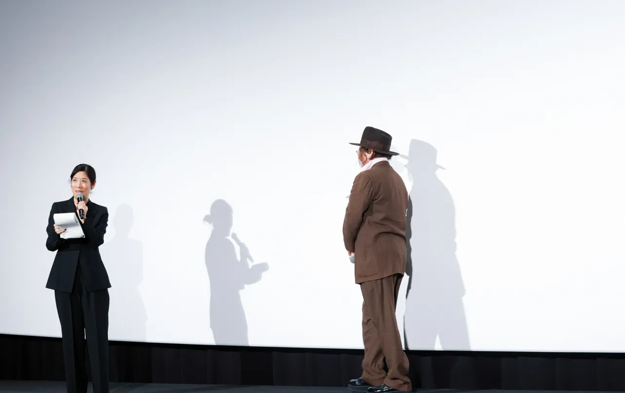 撮影の邪魔にならないよう離れた通訳さんに徐々に近づくジョニー・デップ