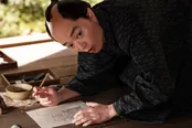 【写真】筆を持つ歌麿(染谷将太)