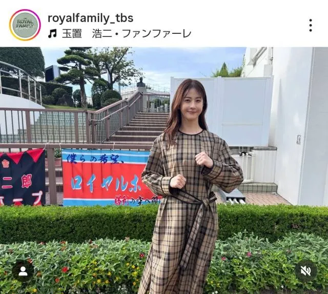 茶色のワンピース姿で小さくガッツポーズ