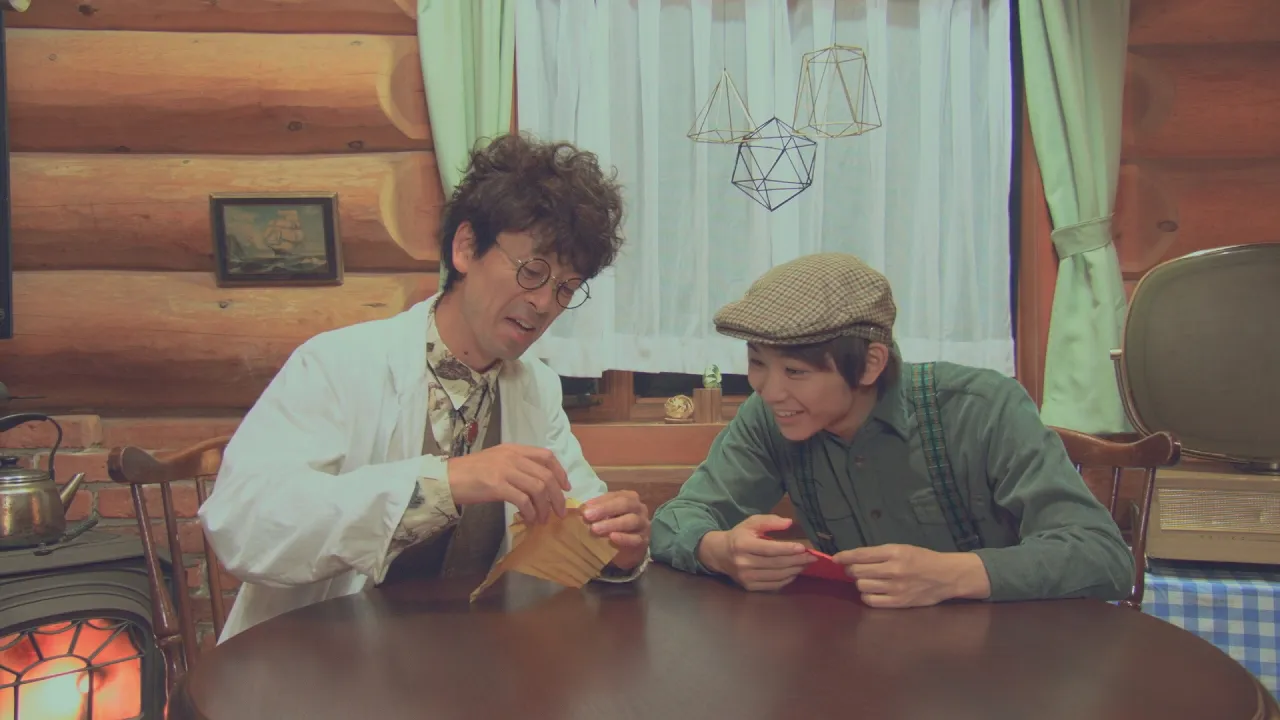 折鶴博士(滝藤賢一)に折り紙を教わる須賀健太(右)