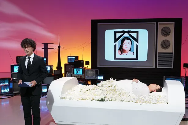 【写真を見る】マツコ・デラックスは白装束を着て、棺で眠っているだけ!?