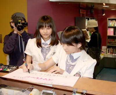 タワーレコード渋谷店でポスターにサインを入れるメンバー