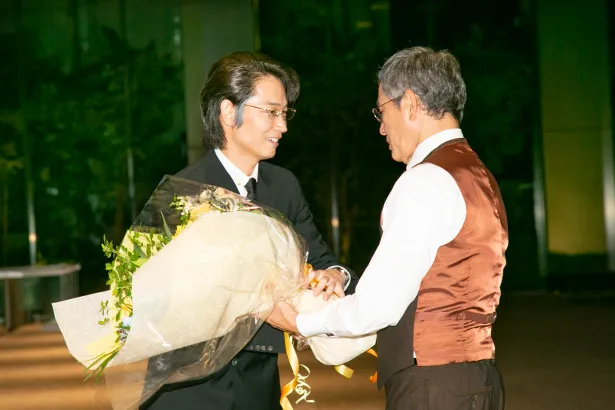【写真を見る】無事にクランクアップを迎えた綾野剛は、共演した小林薫とガッチリと握手！