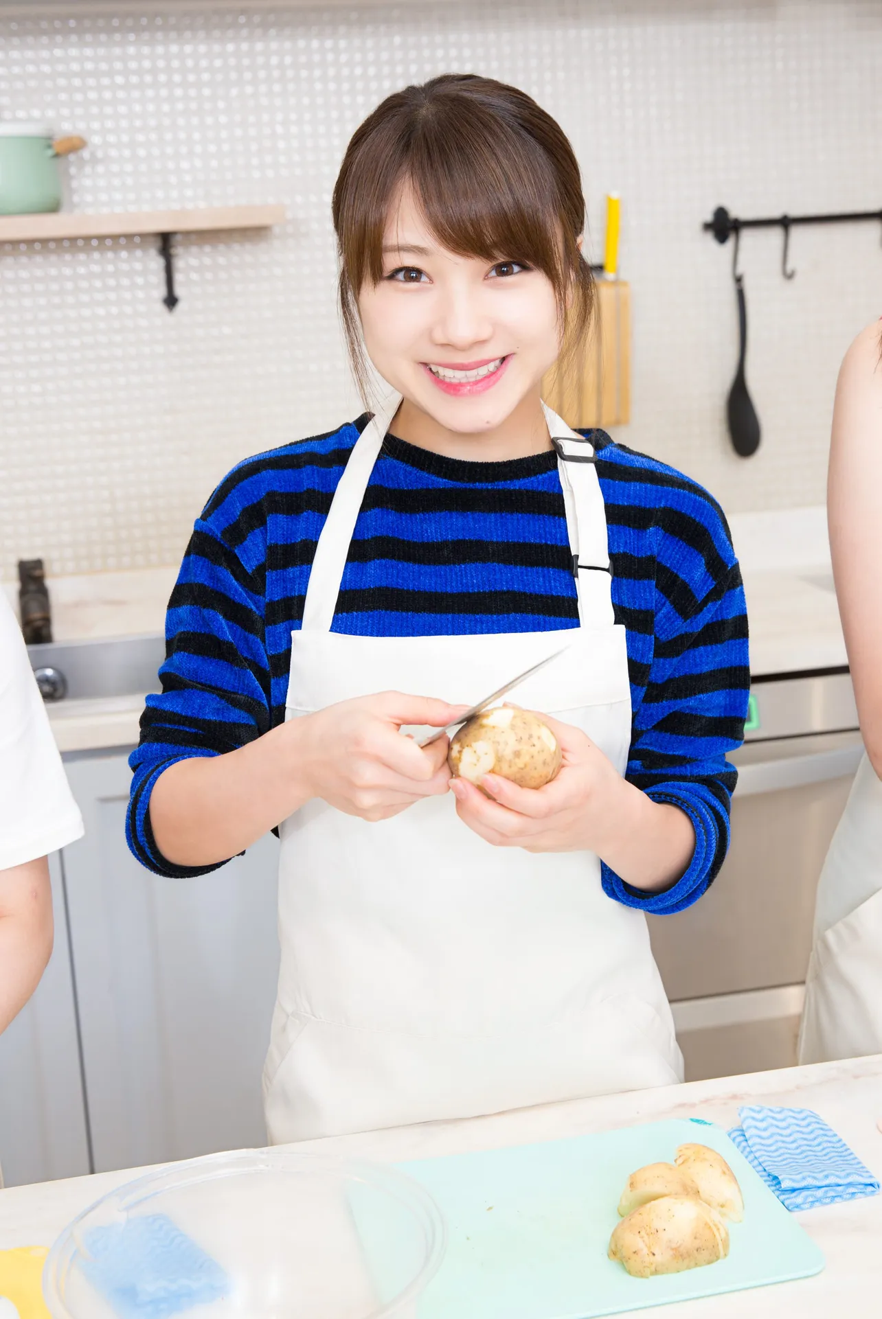 【写真を見る】笑顔でじゃがいもの皮をむく石田亜佑美。でも、料理をする際は野菜の皮は使う派です！